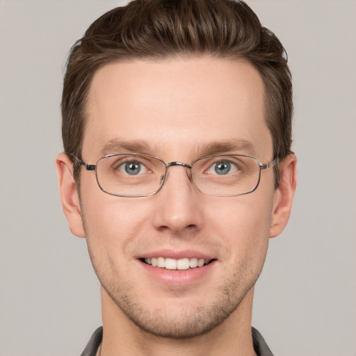 Joyful white young-adult male with short  brown hair and grey eyes