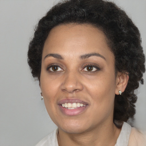 Joyful black young-adult female with medium  brown hair and brown eyes