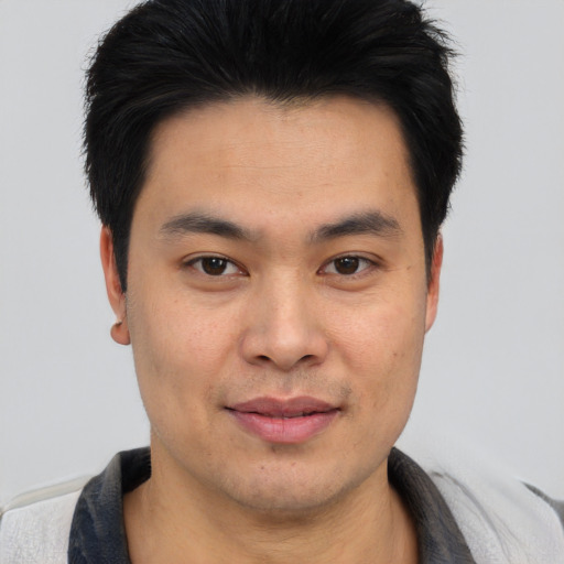 Joyful asian young-adult male with short  black hair and brown eyes