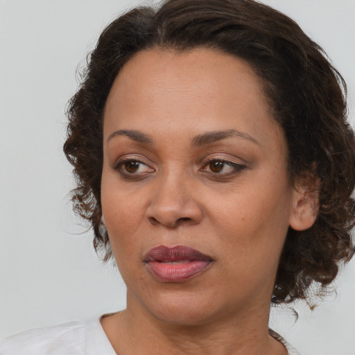 Joyful black adult female with medium  brown hair and brown eyes