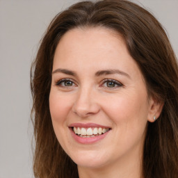 Joyful white young-adult female with long  brown hair and green eyes