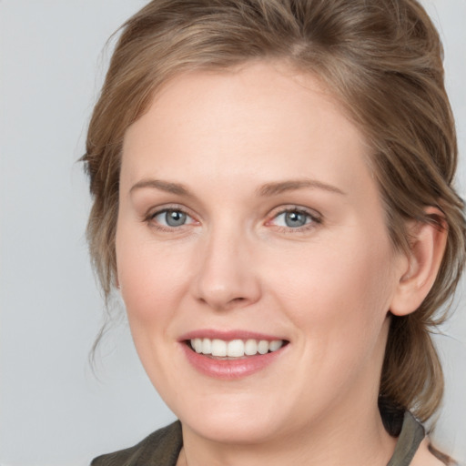 Joyful white young-adult female with medium  brown hair and grey eyes