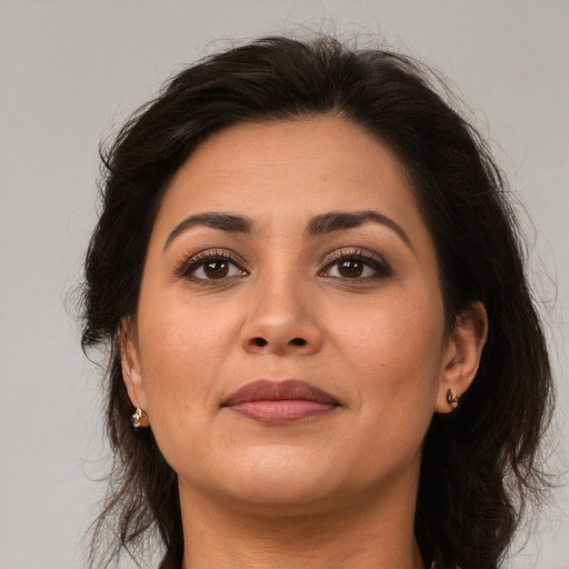 Joyful latino adult female with medium  brown hair and brown eyes