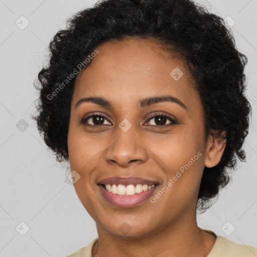 Joyful black young-adult female with long  black hair and brown eyes