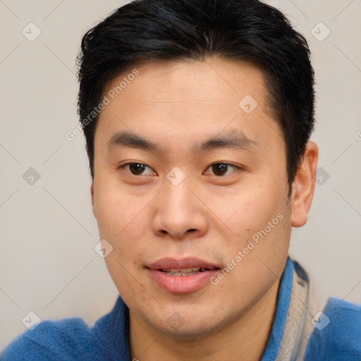 Joyful asian young-adult male with short  brown hair and brown eyes