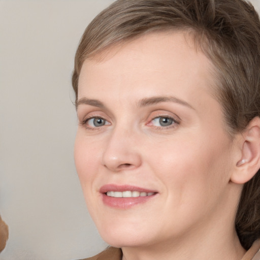 Joyful white young-adult female with short  brown hair and grey eyes