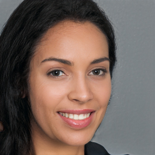 Joyful latino young-adult female with long  brown hair and brown eyes