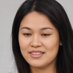 Joyful asian young-adult female with long  brown hair and brown eyes