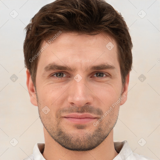 Joyful white young-adult male with short  brown hair and grey eyes