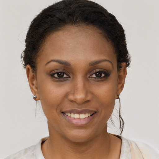Joyful black young-adult female with short  brown hair and brown eyes