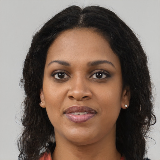 Joyful black young-adult female with long  brown hair and brown eyes