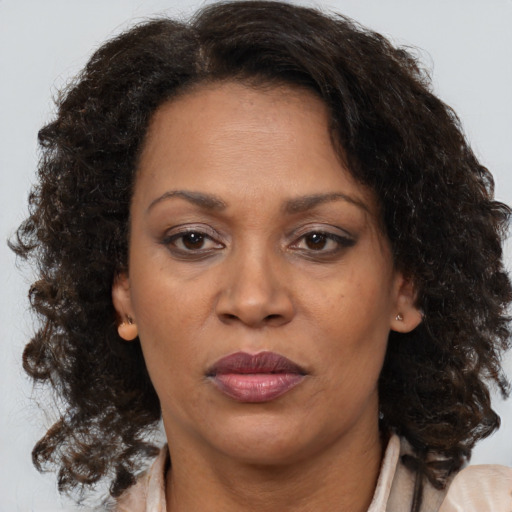 Joyful black adult female with medium  brown hair and brown eyes