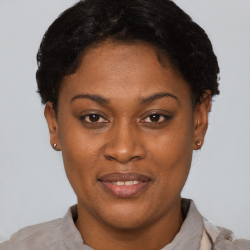 Joyful black young-adult female with short  brown hair and brown eyes