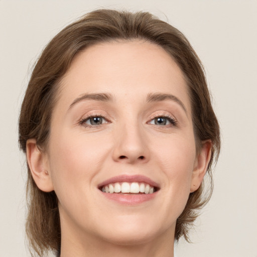 Joyful white young-adult female with medium  brown hair and green eyes