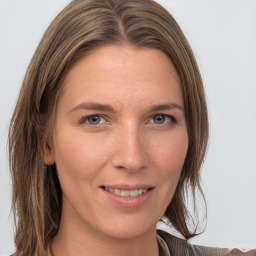 Joyful white adult female with long  brown hair and grey eyes