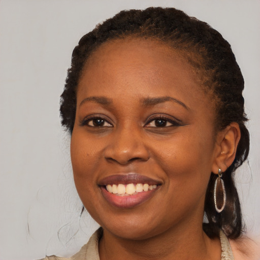 Joyful black young-adult female with long  brown hair and brown eyes