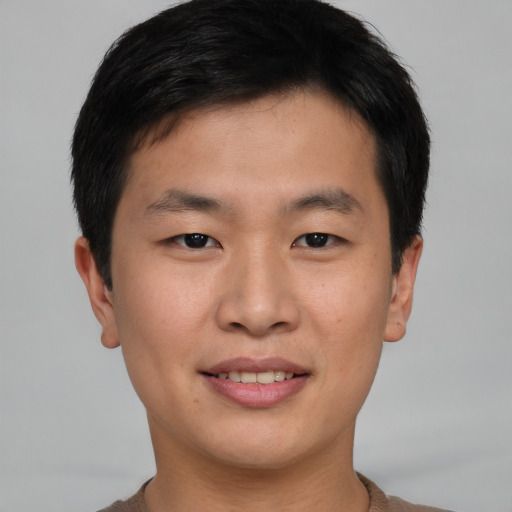 Joyful asian young-adult male with short  brown hair and brown eyes