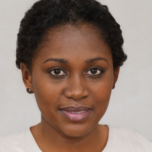 Joyful black young-adult female with short  brown hair and brown eyes