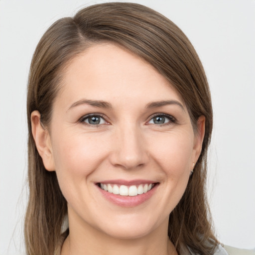 Joyful white young-adult female with long  brown hair and grey eyes