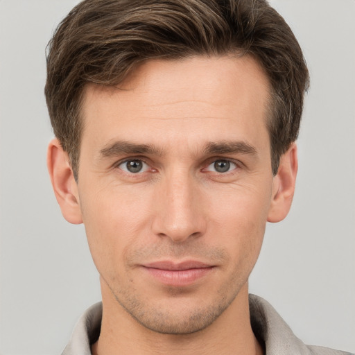 Joyful white young-adult male with short  brown hair and grey eyes