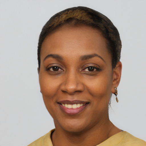 Joyful black young-adult female with short  black hair and brown eyes