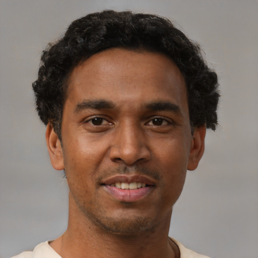 Joyful black young-adult male with short  black hair and brown eyes