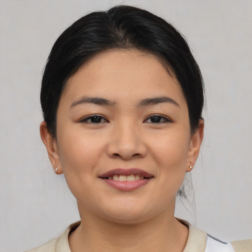 Joyful asian young-adult female with short  brown hair and brown eyes