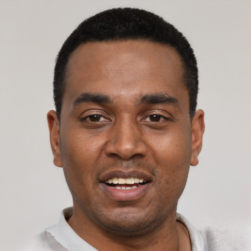 Joyful black young-adult male with short  black hair and brown eyes