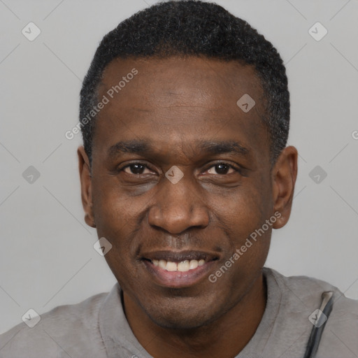 Joyful black adult male with short  black hair and brown eyes