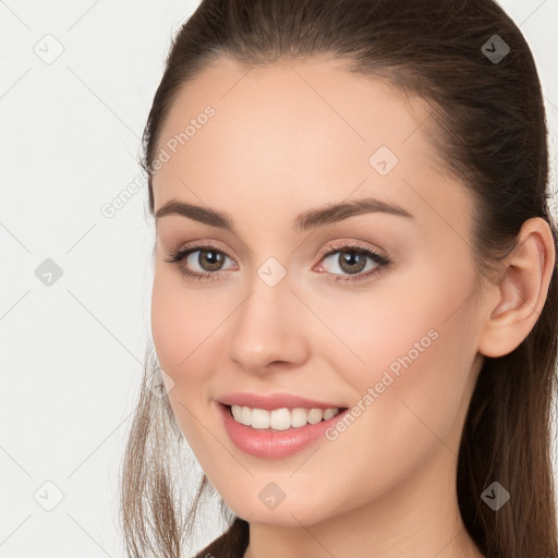 Joyful white young-adult female with long  brown hair and brown eyes