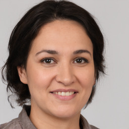 Joyful white adult female with medium  brown hair and brown eyes