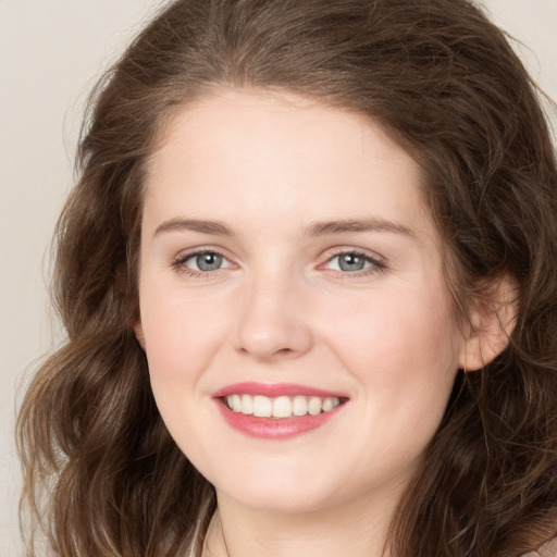 Joyful white young-adult female with long  brown hair and green eyes