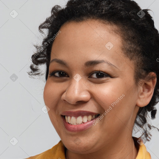 Joyful black young-adult female with short  brown hair and brown eyes