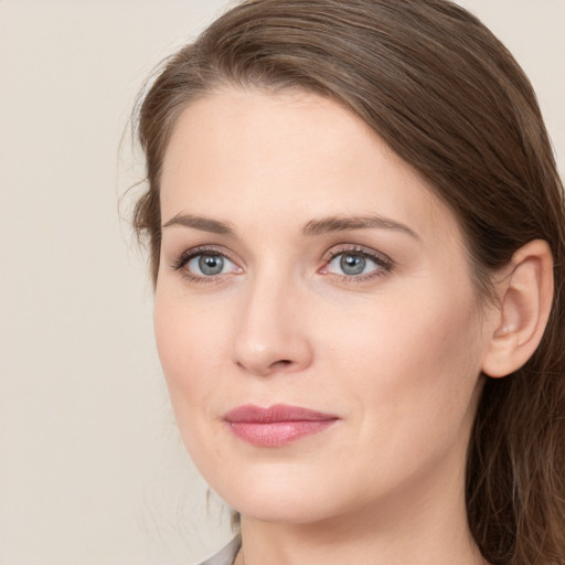 Joyful white young-adult female with long  brown hair and green eyes