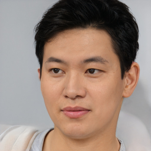Joyful asian young-adult male with short  brown hair and brown eyes