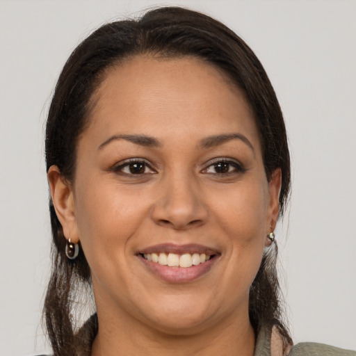 Joyful latino adult female with long  brown hair and brown eyes