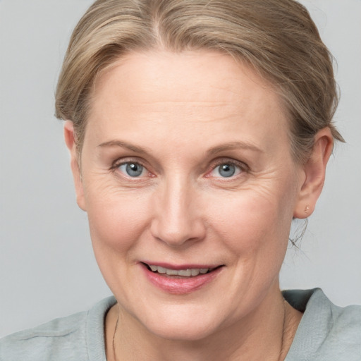 Joyful white adult female with medium  brown hair and blue eyes