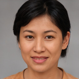 Joyful asian young-adult female with medium  brown hair and brown eyes