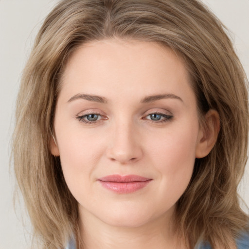 Joyful white young-adult female with long  brown hair and blue eyes