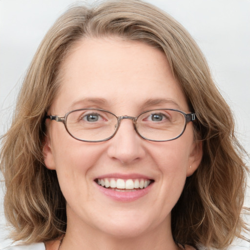 Joyful white adult female with long  brown hair and blue eyes