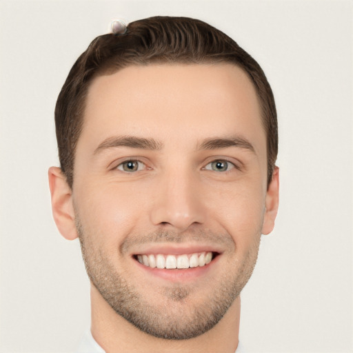 Joyful white young-adult male with short  brown hair and grey eyes