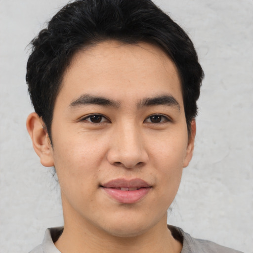 Joyful asian young-adult male with short  black hair and brown eyes