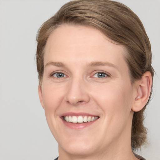 Joyful white adult female with medium  brown hair and blue eyes