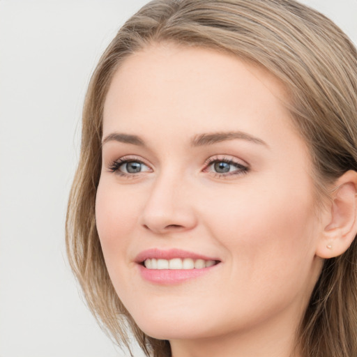 Joyful white young-adult female with long  brown hair and blue eyes