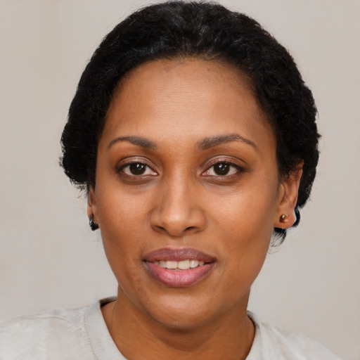 Joyful black adult female with short  black hair and brown eyes