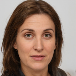 Joyful white adult female with long  brown hair and grey eyes