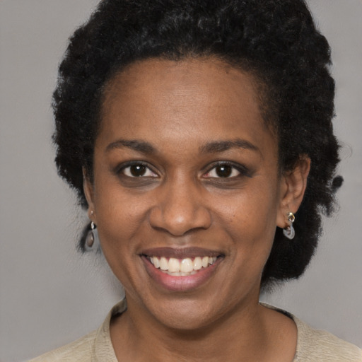Joyful black adult female with short  black hair and brown eyes