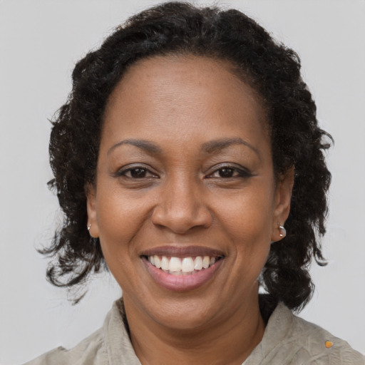 Joyful black adult female with medium  brown hair and brown eyes