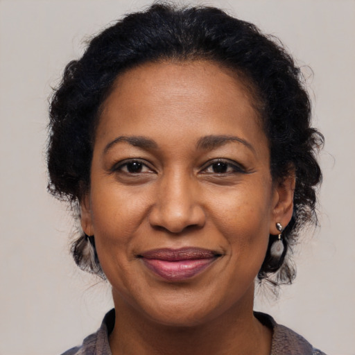 Joyful black adult female with medium  brown hair and brown eyes