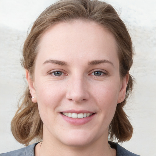 Joyful white young-adult female with medium  brown hair and blue eyes